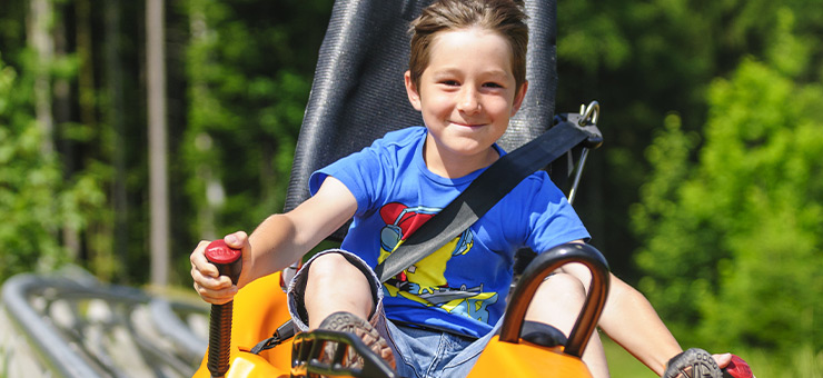 Ein Junge fährt mit dem Alpine Coaster